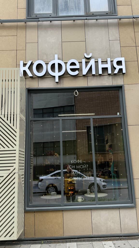 Витрина кофейни с вывеской и надписью на стекле